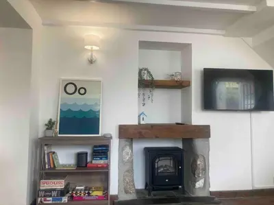 a living room with a fireplace and a tv at 2-bedroom cottage in heart of St Ives w/ parking in St Ives