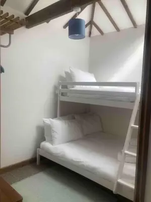 a room with two bunk beds and a ladder at 2-bedroom cottage in heart of St Ives w/ parking in St Ives