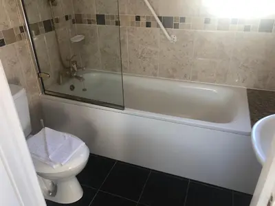 a bathroom with a tub and a toilet and a sink at Southcote Accommodation in Tintagel