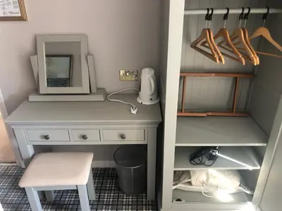a desk with a mirror and a chair in a room at Southcote Accommodation in Tintagel
