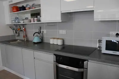 a kitchen with a sink and a microwave at May View - Luxury Sea View Apartment - Millendreath, Looe in Looe