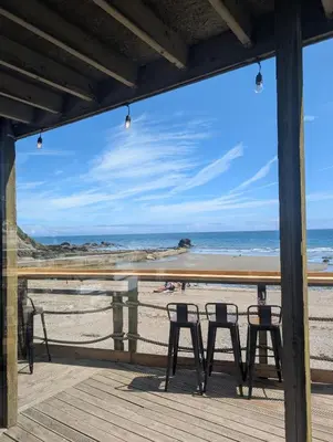 a view of the beach from a deck at May View - Luxury Sea View Apartment - Millendreath, Looe in Looe
