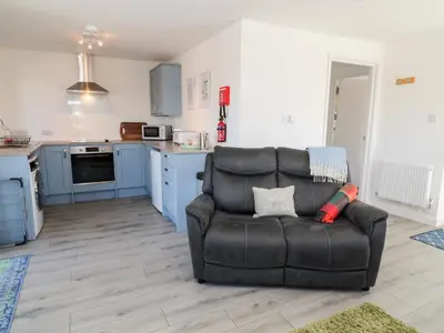 a living room with a couch and a kitchen at The View in Bodmin