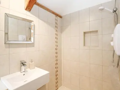 a white bathroom with a sink and a mirror at Godolphin Barn in Helston