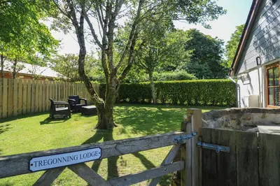 a gate to a garden with a tree at Tregonning Lodge in Helston