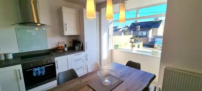 a kitchen with a table with a wine glass on it at Parkside in Perranporth