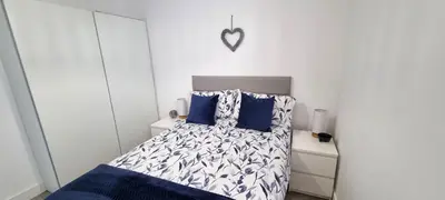 a bedroom with a bed with a blue and white comforter at Parkside in Perranporth