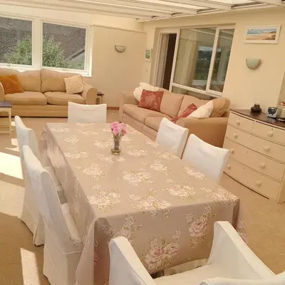 a living room with a table and chairs at Curlews Cottage - House with 3 bedrooms and garden - walking distance to the beach in Perranporth