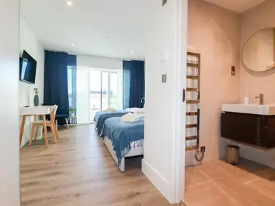 a bedroom with a bed and a bathroom with a sink at 33 Cliff Edge in Newquay
