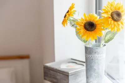 a vase filled with sunflowers sitting on a table at Huckleberry - Premium, Hot Tub, x2 Parking, Farm Shop Next door, Private Cornish Lane in Newquay