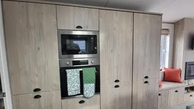 a large wooden cabinet with a television in it at Honeycomb Lodge - Holiday Home 5 min from Padstow in Padstow