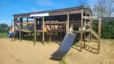 a playground with a slide in front of a building at Honeycomb Lodge - Holiday Home 5 min from Padstow in Padstow