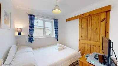 a small bedroom with a bed and a window at A19 Eatondale, Riviere Towans in Hayle