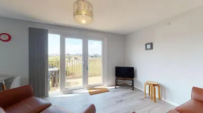 a living room with a couch and a large window at A21 Solano, Riviere Towans in Hayle