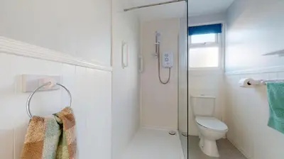 a bathroom with a toilet and a glass shower at A21 Solano, Riviere Towans in Hayle