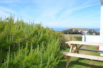 a picnic table sitting next to a field of tall grass at B11 Treague, Riviere Towans in Hayle