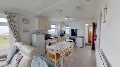 a kitchen with a table and a dining room at B04 Beachcroft B4, Riviere Towans in Hayle