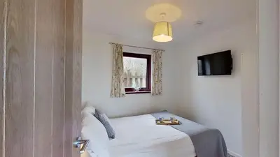 a bedroom with a bed and a window and a door at B04 Beachcroft B4, Riviere Towans in Hayle