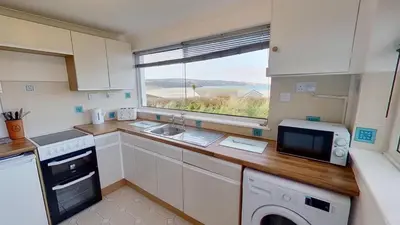 a kitchen with a counter with a microwave and a window at B25 Trezaren, Riviere Towans in Hayle