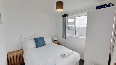 a bedroom with a white bed and a window at B25 Trezaren, Riviere Towans in Hayle