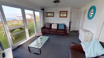 a living room with a couch and a table at B25 Trezaren, Riviere Towans in Hayle