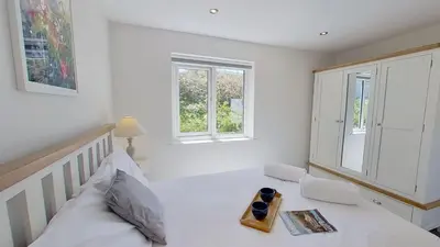 a bedroom with a bed with a book on it at B27 The Lair, Riviere Towans in Hayle