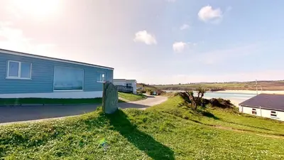 a blue house on the side of a beach at B27 The Lair, Riviere Towans in Hayle