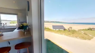 a kitchen with a view of a beach from a window at B27 The Lair, Riviere Towans in Hayle