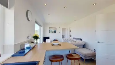 a kitchen and living room with a table and chairs at B27 The Lair, Riviere Towans in Hayle