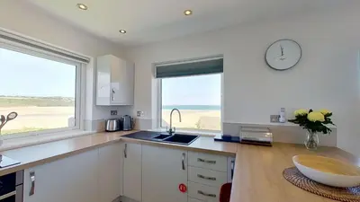 a kitchen with a sink and a clock on the wall at B27 The Lair, Riviere Towans in Hayle