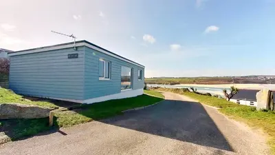a blue tiny house on the side of a road at B27 The Lair, Riviere Towans in Hayle