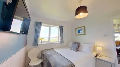 a small bedroom with a bed and a window at B38 Delamar, Riviere Towans in Hayle
