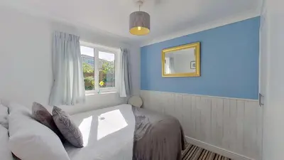 a bedroom with a bed and a window and a mirror at B38 Delamar, Riviere Towans in Hayle