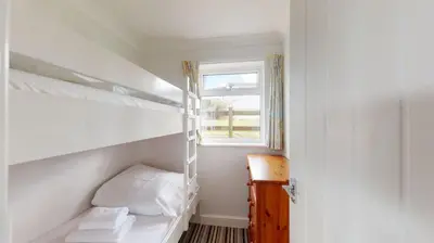 a bedroom with a bunk bed and a window at B38 Delamar, Riviere Towans in Hayle