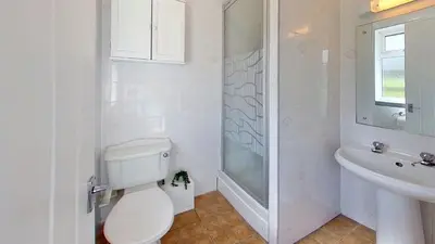 a white bathroom with a toilet and a sink at B38 Delamar, Riviere Towans in Hayle
