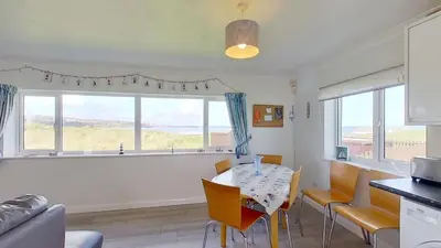 a kitchen and dining room with a table and chairs at B38 Delamar, Riviere Towans in Hayle