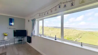 a living room with a large window with a view at B38 Delamar, Riviere Towans in Hayle
