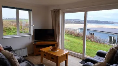 a living room with two couches and a large window at B37 Ebb Tide, Riviere Towans in Hayle