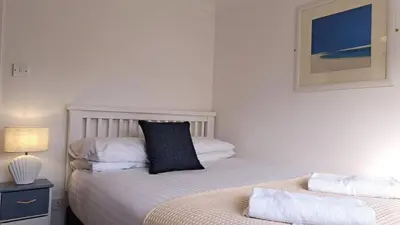 a bedroom with two beds and a picture on the wall at B37 Ebb Tide, Riviere Towans in Hayle