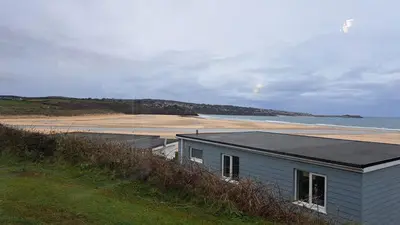 a blue building on the side of a beach at B37 Ebb Tide, Riviere Towans in Hayle