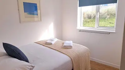 a bedroom with a bed with two towels on it at B37 Ebb Tide, Riviere Towans in Hayle