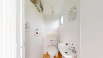 a white bathroom with a toilet and a sink at B14 Amulree, Riviere Towans in Hayle