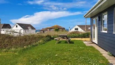 a picnic table in the grass next to a house at A06 Rushdune A6, Riviere Towans in Hayle