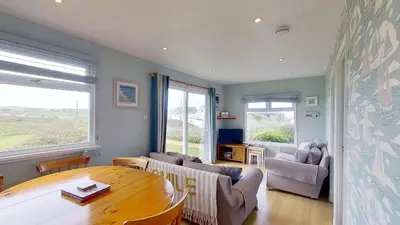 a living room with a table and a couch and chairs at A06 Rushdune A6, Riviere Towans in Hayle