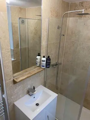 a bathroom with a sink and a glass shower at Homely Beachside Apartment in Newquay Town Centre! in Newquay