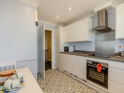 a kitchen with white cabinets and a counter top at Seascape in Porthleven