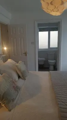 a bedroom with a bed with pillows and a window at The Picture House Stylish Apartment in Fowey in Fowey