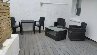 a group of chairs and tables on a patio at The Picture House Stylish Apartment in Fowey in Fowey