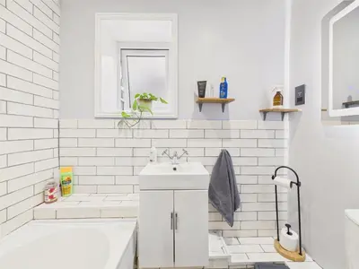 a white bathroom with a tub and a sink at Stylish Central Famouth Studio with Parking | WiFi | in Falmouth