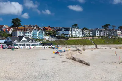 a beach with a group of people and houses at Central Falmouth Flat with Free Parking in Falmouth